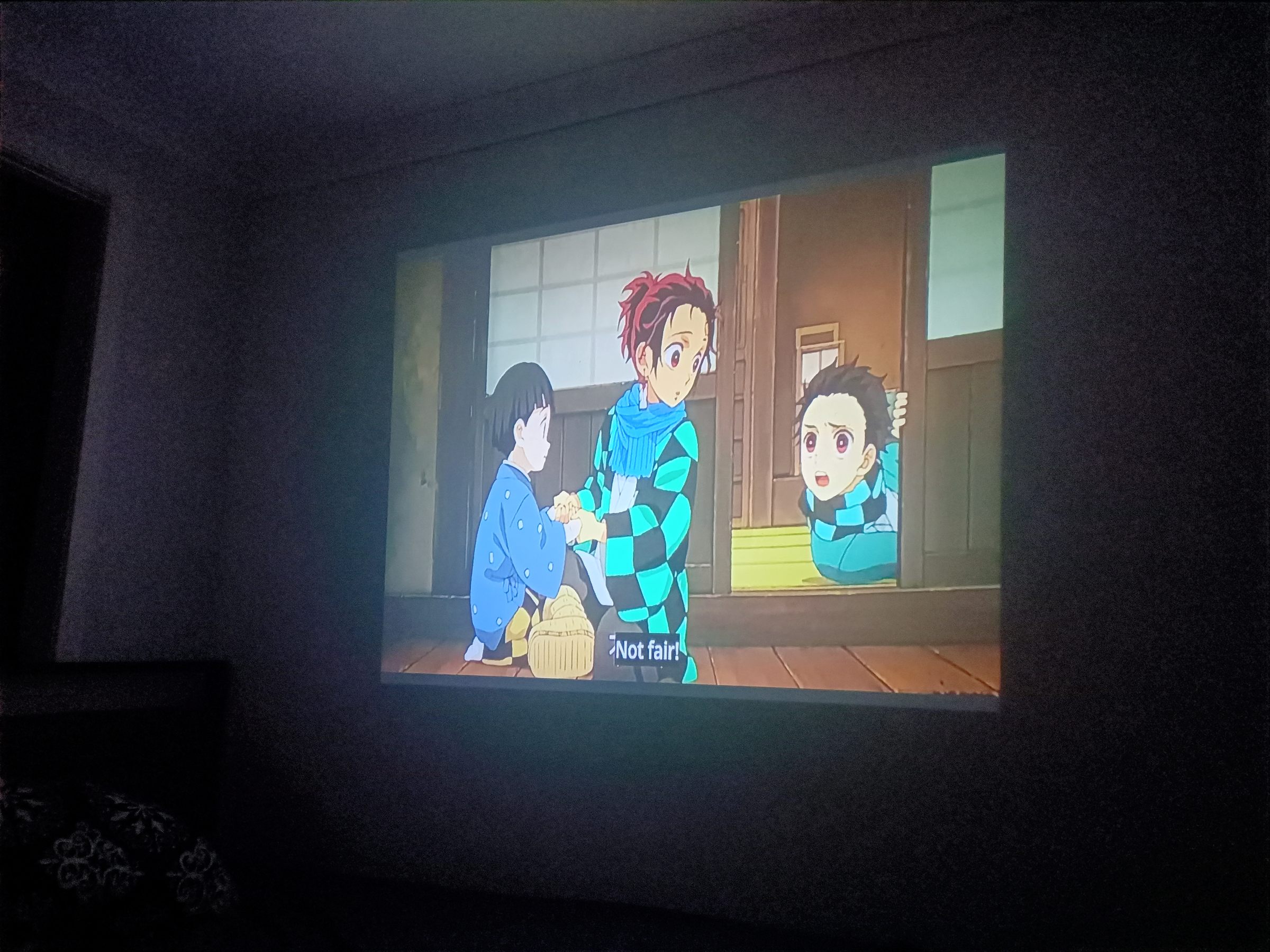 A scene from Demon Slayer projected onto a bedroom wall